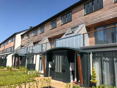 an apartment building with a green door and windows at Sidings at Brunel Two in Lostwithiel