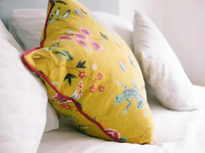 a yellow pillow on a bed with white pillows at Sidings at Brunel Two in Lostwithiel