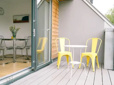a patio with yellow chairs and a table at Sidings at Brunel Two in Lostwithiel