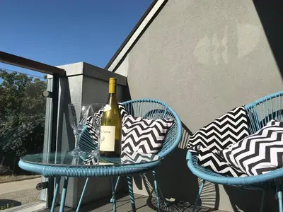 a bottle of wine sitting on a table with two chairs at Sidings at Brunel Two in Lostwithiel