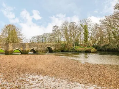 a stone bridge over a river in a park at Sidings at Brunel Two in Lostwithiel