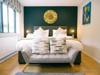 a bedroom with a bed with a couch with pillows at Sidings at Brunel Two in Lostwithiel