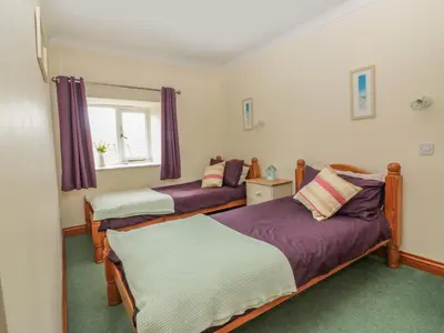 a bedroom with two beds and a window at Sorrel Cottage in Padstow