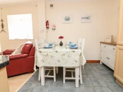 a kitchen and dining room with a table and chairs at Sorrel Cottage in Padstow