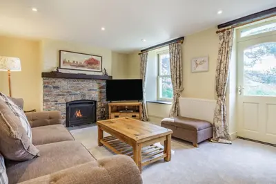 a living room with a couch and a fireplace at Tregoninny Vineyard and Woodland Farmhouse in Truro