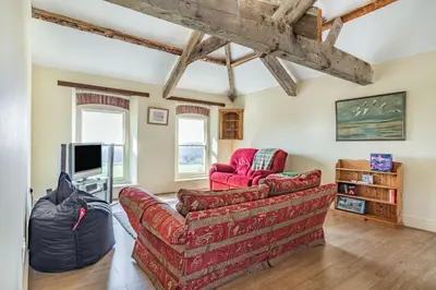 a living room with a couch and a tv at Tregoninny Vineyard and Woodland Farmhouse in Truro