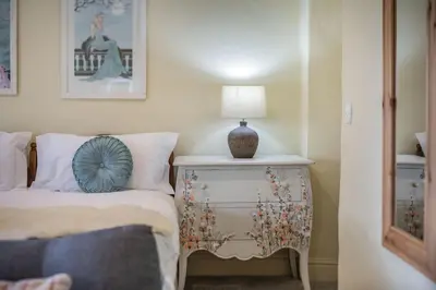 a bedroom with a bed and a lamp on a nightstand at Tregoninny Vineyard and Woodland Farmhouse in Truro