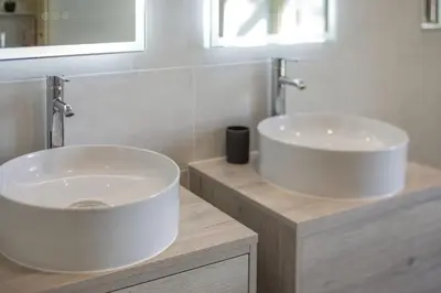 a bathroom with two sinks and a mirror at Tregoninny Vineyard and Woodland Farmhouse in Truro