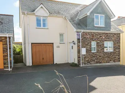 a white house with a brown garage at Jacks Mews in Tintagel
