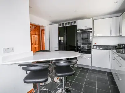 a kitchen with a white counter and black appliances at Jacks Mews in Tintagel