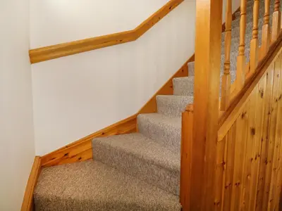 a staircase in a home with wooden floors and a stair case at Jacks Mews in Tintagel