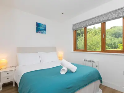a bedroom with a bed with two lamps and a window at Tressa, Tor Down Quarry in Bodmin