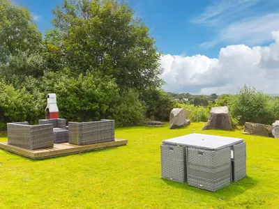 a garden with a lighthouse and rocks in the grass at Tressa, Tor Down Quarry in Bodmin