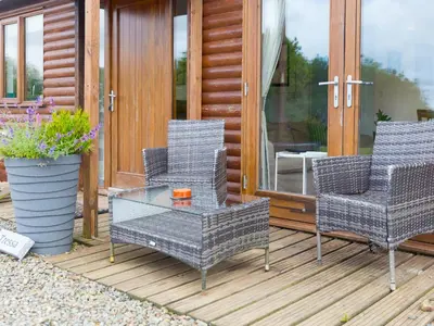 a patio with three chairs and a glass table at Tressa, Tor Down Quarry in Bodmin