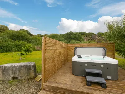 a hot tub sitting on top of a wooden deck at Tressa, Tor Down Quarry in Bodmin