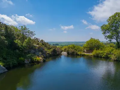 a river with a bridge in the middle at Tressa, Tor Down Quarry in Bodmin