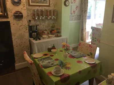 a dining room table with a green table cloth and chairs at Jasmine House in Newquay