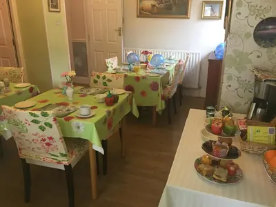 a dining room with tables and chairs with plates of food at Jasmine House in Newquay