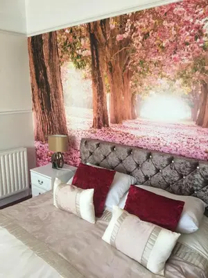 a bedroom with a wall mural of a forest at Jasmine House in Newquay