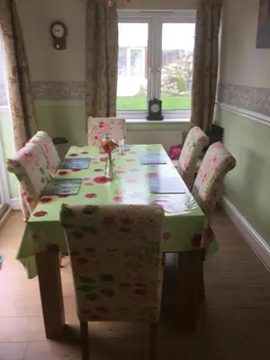 a dining room table with chairs and a green table cloth at Jasmine House in Newquay