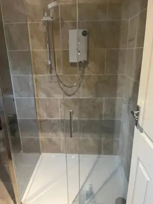 a shower with a glass door in a bathroom at Jasmine House in Newquay