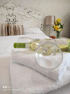 a white bed with towels and a wine glass on it at The Cornishman Inn in Tintagel