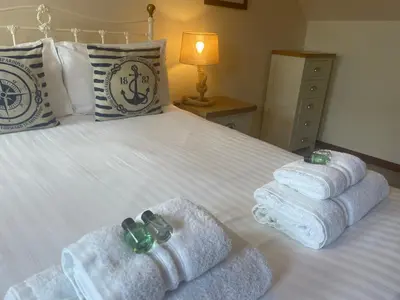 a bedroom with a bed with towels on it at The Cornishman Inn in Tintagel
