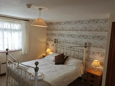 a bedroom with a bed with a wooden wall at The Cornishman Inn in Tintagel