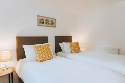 two beds sitting next to each other in a room at Goonwinnow Farm Cottages in Newquay