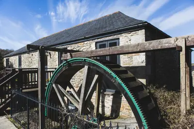 a building with a wooden bridge in front of it at Goonwinnow Farm Cottages in Newquay