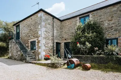 a brick house with some pots in front of it at Wheel House @ Goonwinnow Farm in Newquay