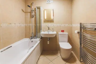a bathroom with a toilet and a sink and a tub at Wheel House @ Goonwinnow Farm in Newquay