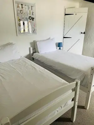 two beds sitting next to each other in a bedroom at Mill House @ Goonwinnow Farm in Newquay