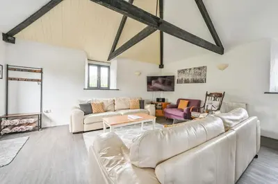 a living room with a couch and a table at Mill House @ Goonwinnow Farm in Newquay
