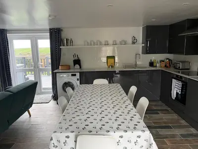 a kitchen with a table and a table and chairs at The Piggery @ Goonwinnow Farm in Newquay