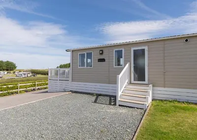 a tiny house with a staircase in a yard at Trevornick Holiday Park in Holywell Bay