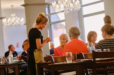 a group of people sitting at tables in a restaurant at The Kilbirnie Hotel in Newquay