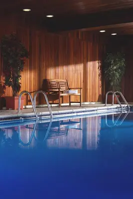 a swimming pool with two chairs and a table at The Kilbirnie Hotel in Newquay