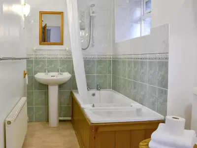 a bathroom with a sink and a tub and a toilet at Granny's Cottage in Lostwithiel