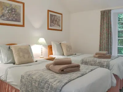 a bedroom with two beds with towels on them at Granny's Cottage in Lostwithiel