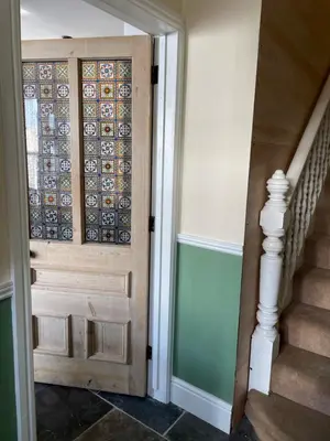 a wooden door in a hallway with a staircase at Fistral Court in Newquay