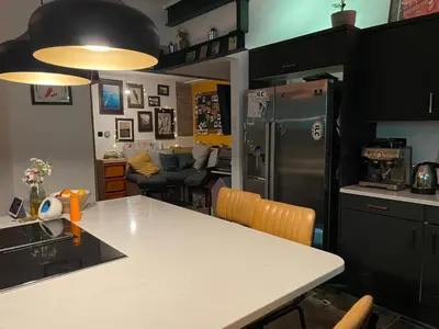 a kitchen with a refrigerator and a table with chairs at Fistral Court in Newquay