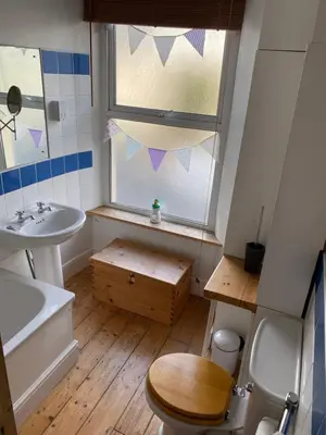 a bathroom with a toilet and a sink and a window at Fistral Court in Newquay