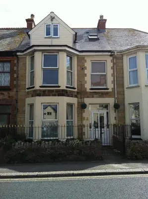 a house with a fence in front of it at Fistral Court in Newquay