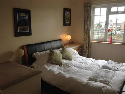 a bedroom with a white bed with pillows and a window at Fistral Court in Newquay