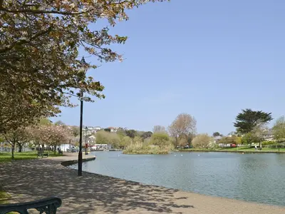 a park with a bench next to a lake at Towan View in Newquay