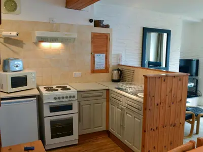 a kitchen with a stove and a microwave at Towan View in Newquay