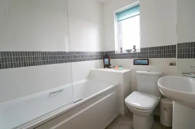 a bathroom with a tub and a toilet and a sink at MODERN HOLIDAY HOME central St Merryn in St Merryn