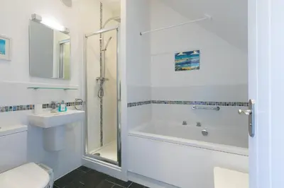 a bathroom with a tub and a toilet and a sink at SeaCrest 1 in St Ives