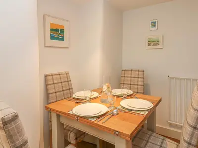 a dining room table with plates and glasses on it at Lantern Cottage in Padstow